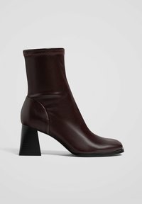 Burgundin nahasta valmistettu nilkkuri, jossa on säädetty muotoilu, neliönmuotoinen varvas ja teksturoitu musta paljaspohja. Sisältää kontrastivärisiä ompelusaumoja.