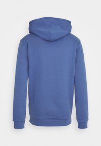 Huvtröja i en enhetlig blå färg, med en slät textur, långa ärmar och ribbat avslut. Designen är enkel och avslappnad.