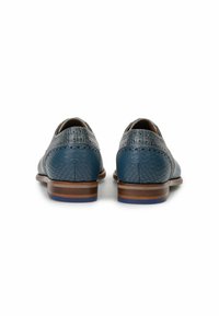 Scarpe in pelle di colore blu scuro con finitura testurizzata e dettagli perforati. Tacco impilato marrone con un accento blu alla base.