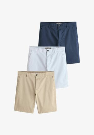 Drie paar op maat gemaakte herenshorts in beige, wit en marineblauw, elk met riemlussen, voorzakken en knoopsluitingen.
