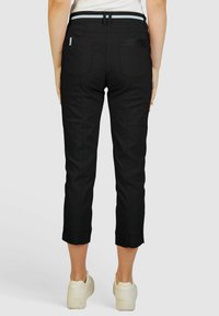 Zwarte cropped broek met een aansluitend ontwerp, voorzien van een contrasterende tailleband, achterzakken en een soepele textuur.
