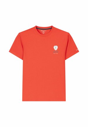 Camiseta roja de manga corta con cuello redondo, con un pequeño logo de escudo blanco y azul en el pecho izquierdo y texto blanco en la manga izquierda.