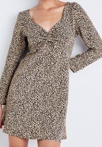 Robe imprimé léopard beige et noir, dotée d'un profond décolleté en V, de manches longues et d'un nœud à la taille, confectionnée en tissu léger.