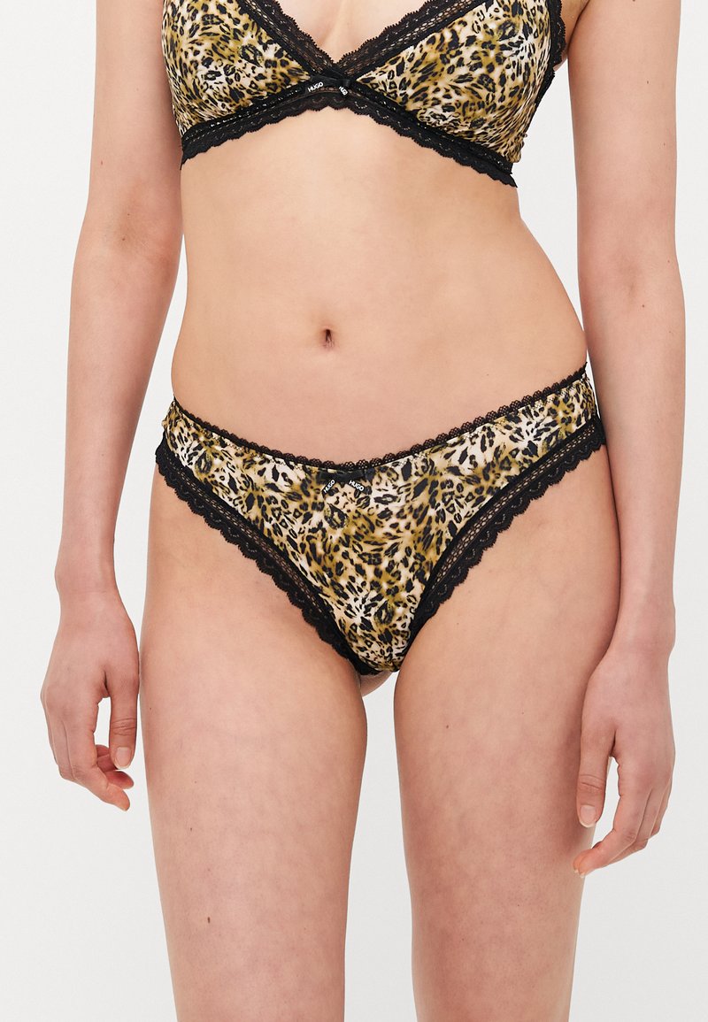 Ensemble de soutien-gorge et culotte avec un imprimé léopard beige et marron, avec des accents en dentelle noire le long des bords et une texture douce.