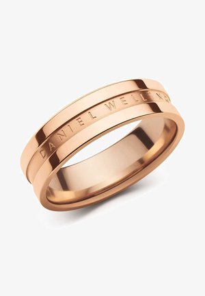 Ruusu-kultainen sormus, jossa on sileä ja kiillotettu pinta. Ominaisuuksina kaksoisnauhamuotoilu, jossa on kaiverrettu teksti "DANIEL WELLINGTON". Yksinkertainen ja tyylikäs muoto.