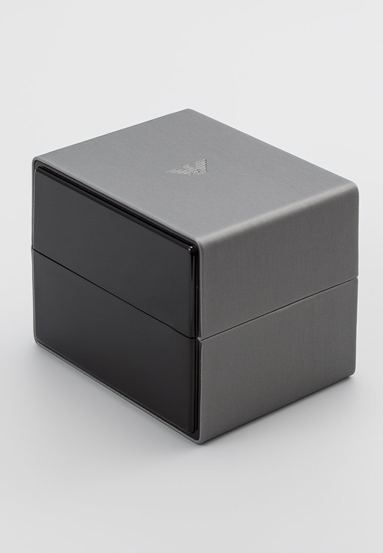 Rechteckige Box mit einer gebürsteten metallischen grauen Oberfläche. Verfügt über einen glänzenden schwarzen unteren Abschnitt und ein erhabenes Logo auf der Oberseite.