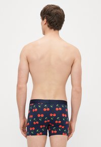 Tumši zili bokseršorti ar ķiršu rakstu — spilgti sarkanas ķiršas un zaļas kātiņas. Elastīgā josta ar uzrakstu "HAPPY".