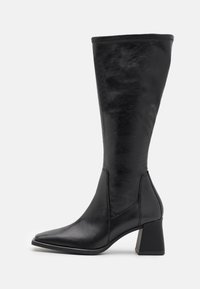 Bota de cuero negro hasta la rodilla con puntera afilada y tacón grueso. El diseño presenta una textura suave y detalles de costura mínimos.