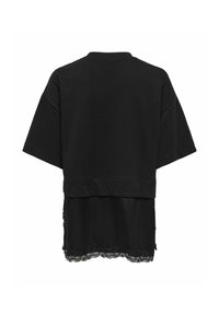 Chemise noire à manches courtes superposées avec des manches larges et une bordure en dentelle au bas, vue de dos sur fond blanc.