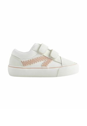 Biele detské tenisky s dvoma suchými zipsami a béžovým cik-cak prešitím na boku, hrubá gumová podrážka.