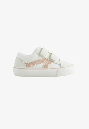 White children's sneaker with two Velcro straps and beige zigzag stitching detail on the side, thick rubber sole.