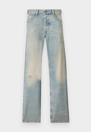 Jean droit en denim bleu clair avec des détails délavés et usés, comprenant de petites déchirures sur les cuisses et une pièce sur la jambe gauche.