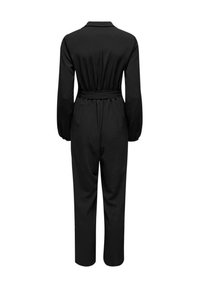 Combinaison noire à manches longues, col rabattu, taille ceinturée et jambes fuselées. Texture lisse sans motifs ni accents visibles.