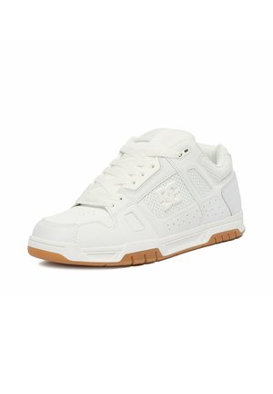 Zapatilla deportiva blanca de caña alta con cuello acolchado, lados perforados, cordones blancos y suela de goma, inclinada para mostrar el lado exterior y el frente.