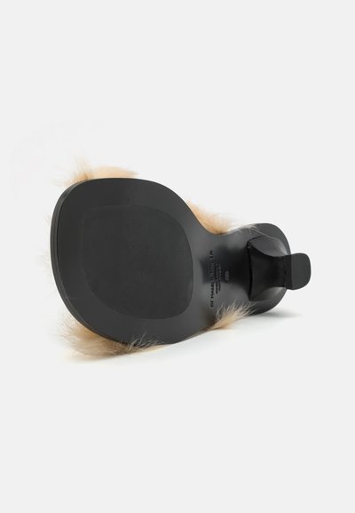 Black sole with a smooth finish, topped with light beige faux fur accents. Open back design with a wide strap for support.