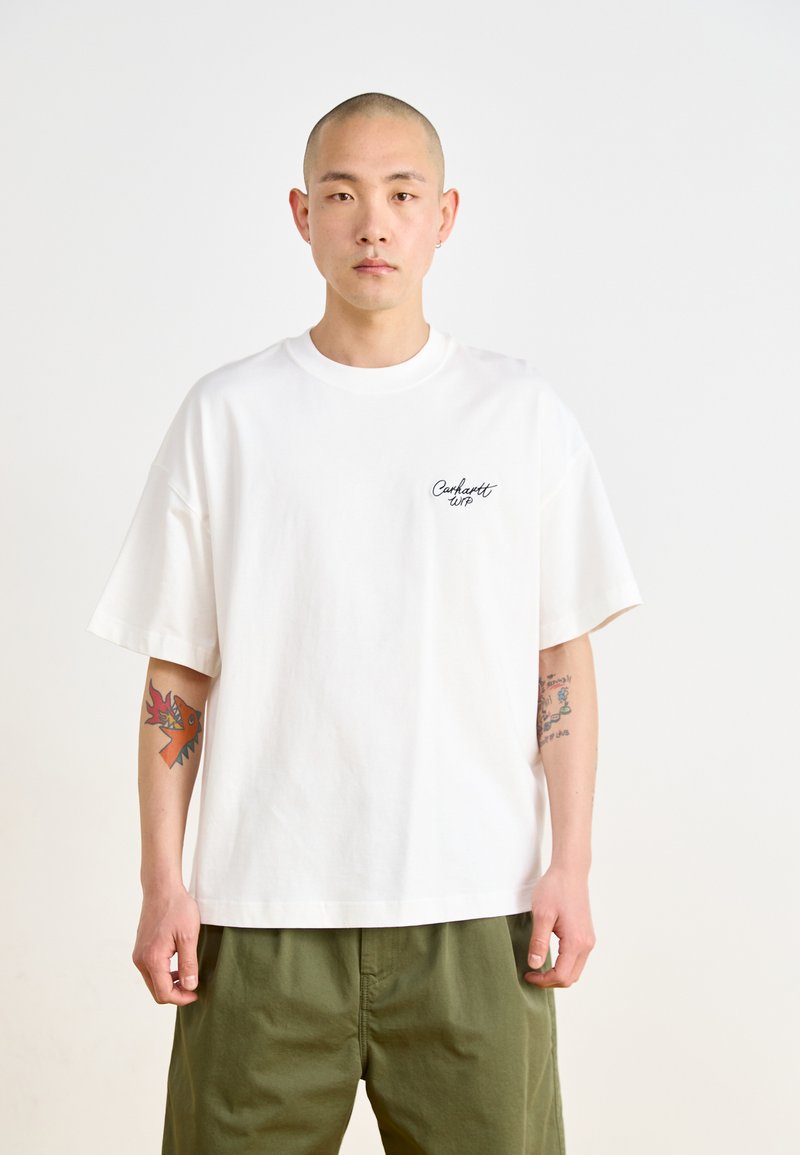 Camiseta de algodón blanca con mangas cortas, cuello redondo y un pequeño logotipo negro de "Carhartt WIP" en el lado izquierdo del pecho. Corte relajado.