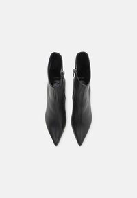 Zwarte leren enkelboots met een puntige neus, voorzien van een zijrits en een gladde textuur. Minimalistische en strakke silhoutte.