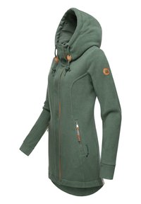 Zaļš vilnas kapuce ar augstu apkakli, regulējamiem stringiem, ādas akcentiem, divām ar rāvējslēdzēju kabatām un izliekto apakšu.