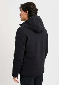 Giacca nera con cappuccio dal finish liscio e opaco. Presenta maniche lunghe, un colletto alto e un branding discreto sulla spalla.