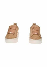 Un paio di scarpe da ginnastica beige con suole bianche spesse e lacci beige abbinati, viste frontalmente su uno sfondo bianco.