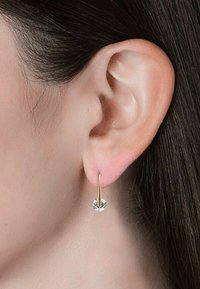 Orecchini a cerchio in oro con un accento di cristallo tondo scintillante. Il design è elegante con una finitura liscia e uno stile minimalista.