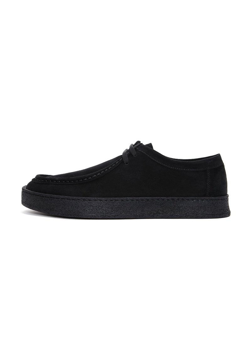 Zapatos de ante negro con punta redonda, perfil bajo y suela de goma plana. Cuentan con costuras y cordones en tonalidad para un ajuste seguro.