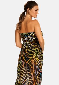 Czarna sukienka maxi bez ramiączek z kolorowym wzorem liści. Wykonana z lekkiego materiału, z elastyczną talią dla luźniejszego fasonu.