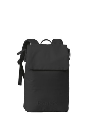 Sac à dos noir avec un rabat, des bretelles ajustables et un tissu texturé. Présente un logo en relief à l'avant. Design simple et fonctionnel.