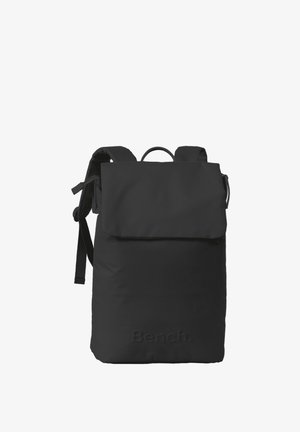 Sac à dos noir avec un rabat, des bretelles ajustables et un tissu texturé. Présente un logo en relief à l'avant. Design simple et fonctionnel.