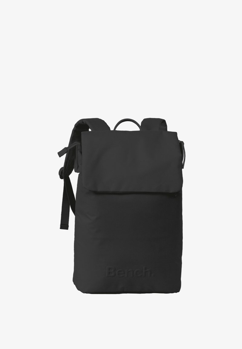 Sac à dos noir avec un rabat, des bretelles ajustables et un tissu texturé. Présente un logo en relief à l'avant. Design simple et fonctionnel.