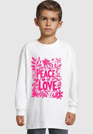 Weißes Langarm-T-Shirt mit einem lebhaften pinken Blumenmuster und den Worten "FRIEDEN" und "LIEBE" in fetter Schrift.