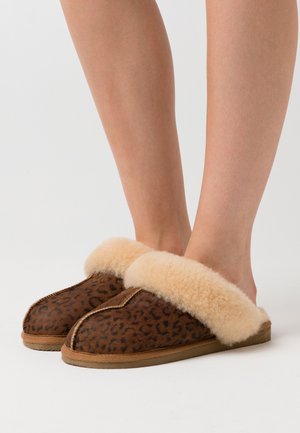 Brown leopard print slippers with a soft, beige fleece cuff, rounded toes, and a flat rubber sole, showcasing a textured material design.