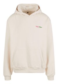 Világos bézs kapucnis pulóver, elülső zsebbel, húzózsinórral a kapucnin, és diszkrét rózsaszín és zöld logóval a bal felső oldalon. Puha szövettextúra.