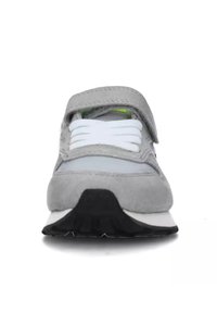 Sneaker grigio realizzata con materiali in suede e mesh, dotata di una fascia in velcro, lacci bianchi, suola in gomma nera e dettagli di design sottili.
