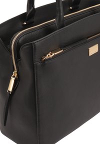 Zwarte leren shopper met gouden ritsaccenten en een rechthoekige vorm. Beschikt over een voorzak met een rits en een merklabel.