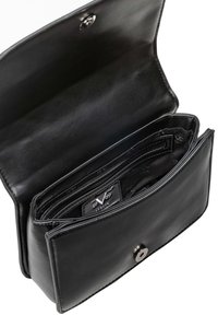 Schwarze Lederbörse, geöffnet, um die Innenfächer und das markierte Futter mit einem Druckknopfverschluss zu zeigen.