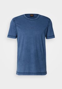 T-shirt bleu à manches courtes avec col rond, logo "BOSS" discrètement brodé sur la poitrine et une étiquette noire à l'intérieur du col.