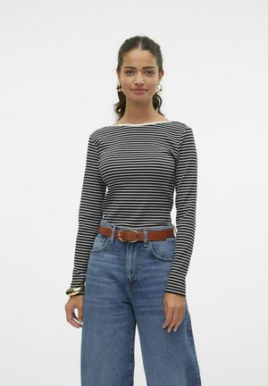 Black and white striped long-sleeve top paired with high-waisted light blue denim jeans and a brown belt, featuring a round neckline.