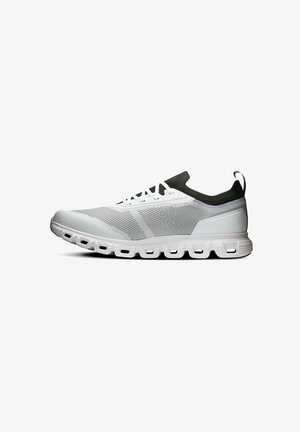 Scarpa da ginnastica bianca e grigia con collarino nero simile a una calza, lati in mesh, lacci bianchi e suola dal motivo unico con segmenti di ammortizzazione aperti.