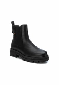 Botas de tobillo de cuero negro con paneles laterales elásticos, una pestaña para ayudar a ponérselas y una suela de goma gruesa y texturizada. Acabado suave con acentos mínimos.