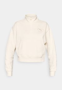 Sweatshirt blanc court avec une demi-fermeture éclair, poche avant et logo en relief. Fabriqué en tissu doux avec des poignets côtelés.