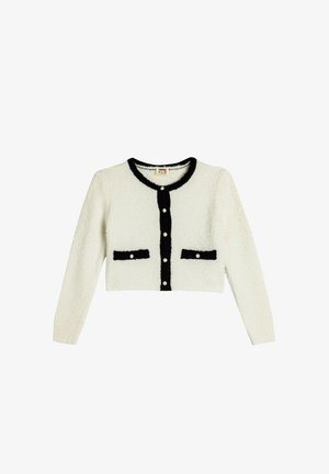 White cropped cardigan with a fuzzy texture, black trim, and two black pockets. Features pearl-like buttons down the front.