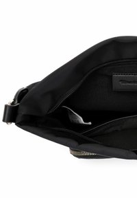 Melnas neilona soma ar rāvējslēdzēju, tajā ir strukturēta iekšpuse un atzīmēta kabata. Minimālistisks dizains bez redzamiem aparatūras elementiem.