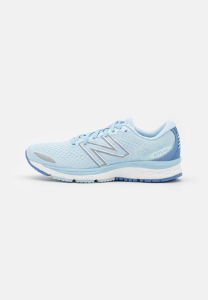 Chaussure de course New Balance bleu clair avec tige en mesh, semelle blanche et bleue, et inscription "Solvi" près du talon sur un fond blanc uni.
