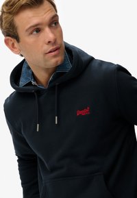 Felpa blu navy con cappuccio e coulisse, dotata di hardware in argento, con il logo rosso Superdry sul petto. Tessuto morbido con vestibilità comoda.