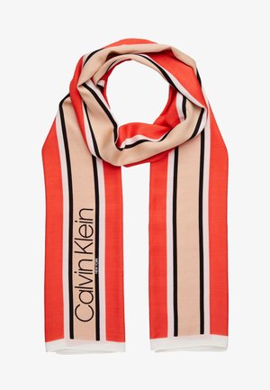 Écharpe rayée rouge et beige avec des lignes noires et blanches, comportant le logo vertical Calvin Klein New York sur un côté.