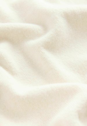 Weicher Creme-Stoff mit glatter Textur, der sanfte Falten und subtile Farbvariationen zeigt, was auf ein leichtes Material hinweist.