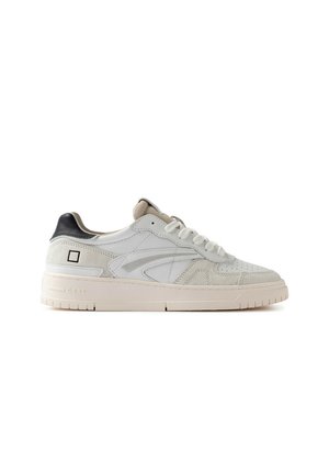 Sneaker bianca low-top con dettagli in camoscio beige, lacci bianchi, linguetta nera sul tallone e suola spessa avorio su sfondo bianco semplice.