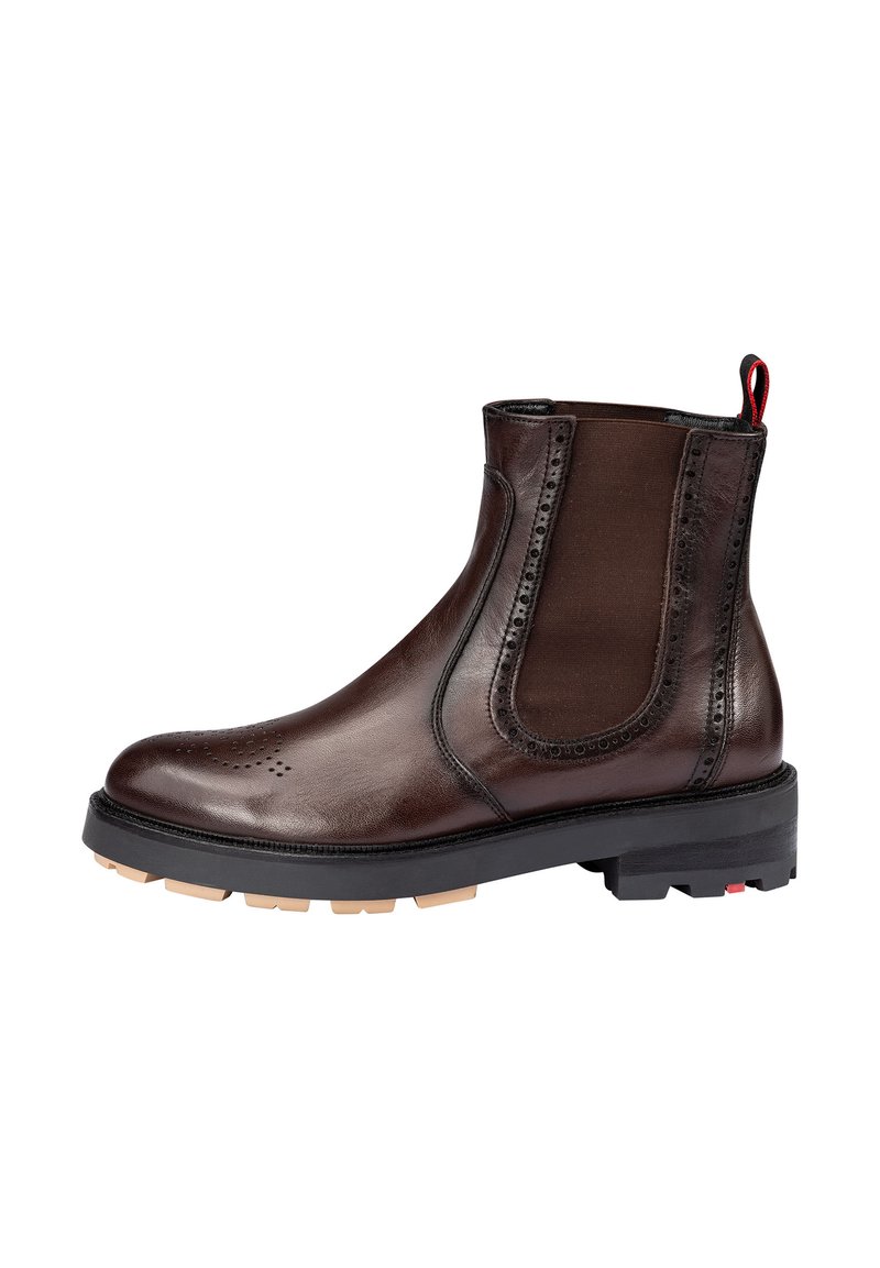 Stivaletti in pelle marrone con pannelli elasticizzati sui lati, dettagli brogue sulla punta, suola in gomma nera e una linguetta rossa sul tallone.