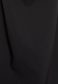 Schwarzer Stoff mit einer glatten, matten Textur und leicht reflektierender Oberfläche, die subtile Falten und Drapierungen zeigt. Keine Muster oder sichtbaren Zubehörteile.